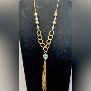 23 inch gold tone necklace with faceted gold and clear beads. Tassel pendant.